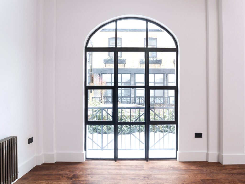 "Custom-bespoke aluminium bifold doors in dark finish folding back to brighten a contemporary living space"
