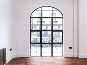 "Custom-bespoke aluminium bifold doors in dark finish folding back to brighten a contemporary living space"